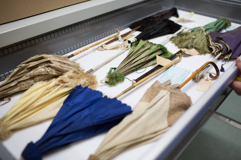 Collection of parasols in an open storage drawer.