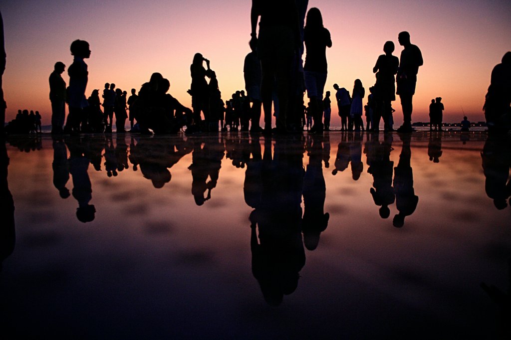 Group of people watching a sunset together.