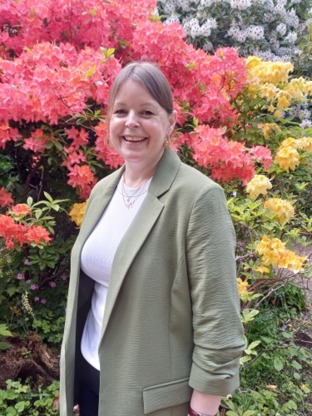 Image of Claudia Baker - Museum Development Office standing in front of a floral display.