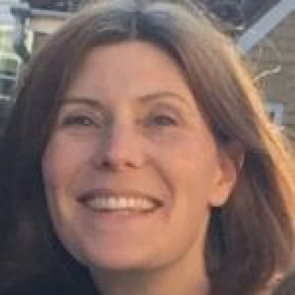 Head shot of smiling Franne who has brown hair.